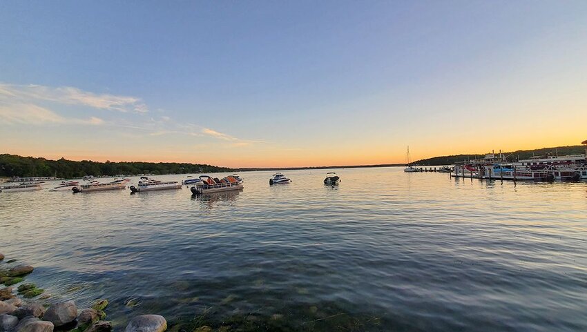 Boats floating in Lake Geneva during sunset. 