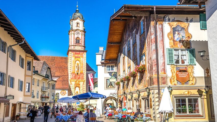 Street with people and church in Mittenwald, Germany. 