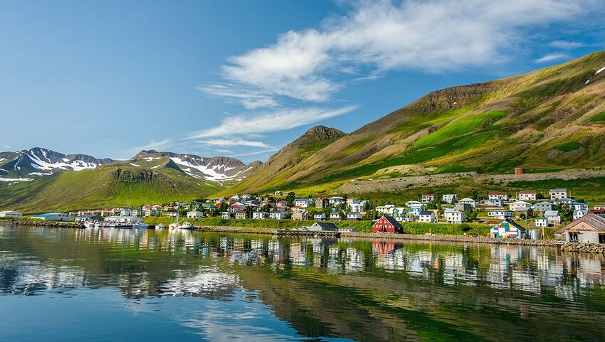 Village of Siglufjordur along water.