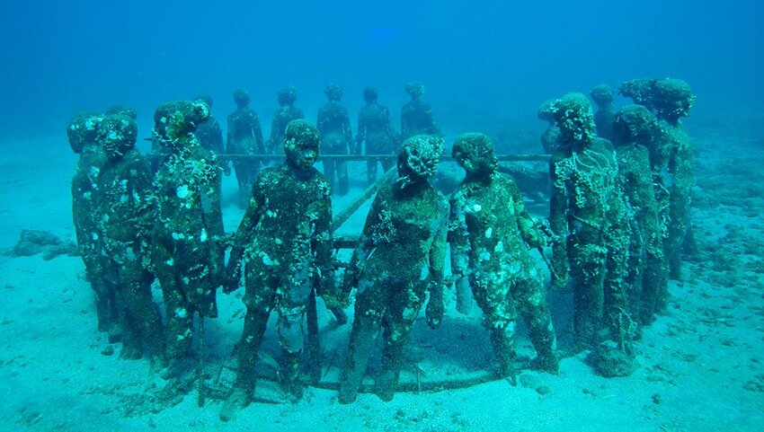 Underwater sculpture of people in a circle.