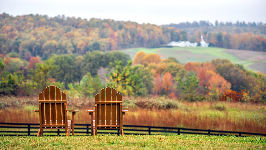 Two wooden chairs in autumn fall foliage season countryside at Charlottesville winery