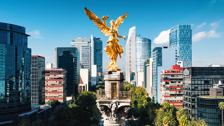Aerial view of Independence Monument in Mexico City with skyscrapers behind it.