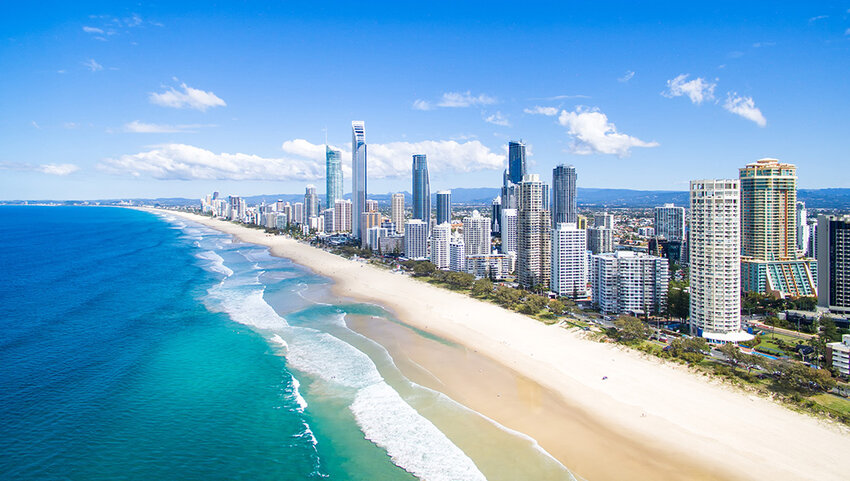 Sandy beach with line of skyscrapers.