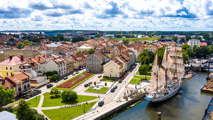 Aerial of Klaipėda, with building and large boat in canal.