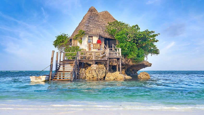 Restaurant on rock in ocean.