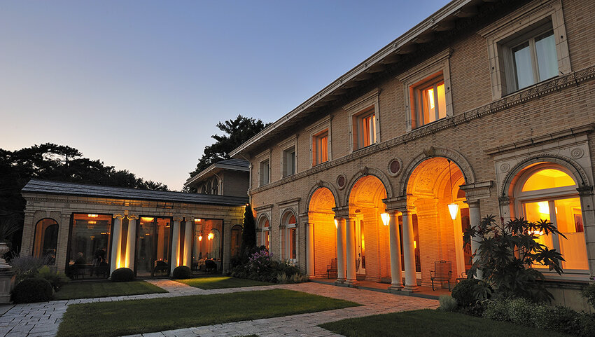 Exterior of The Wheatleigh at dusk, with lights on the porch.