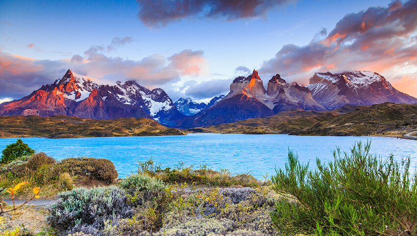 Lake with mountains in distance at sunrise.
