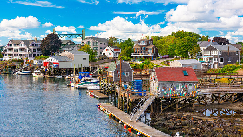 Docked boats, fishing shacks, and houses on river.