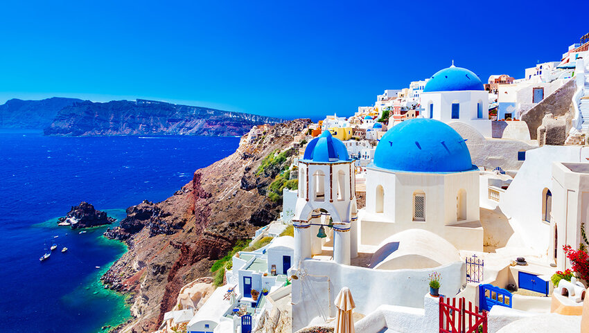 Traditional and famous houses and churches with blue domes over the Caldera, Aegean sea.
