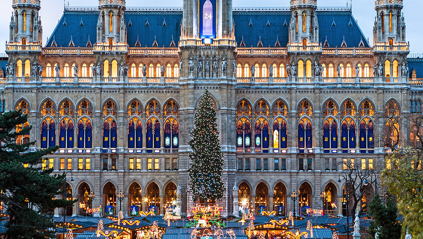 Building, Christmas tree, and tops of stalls and Christmas Market.
