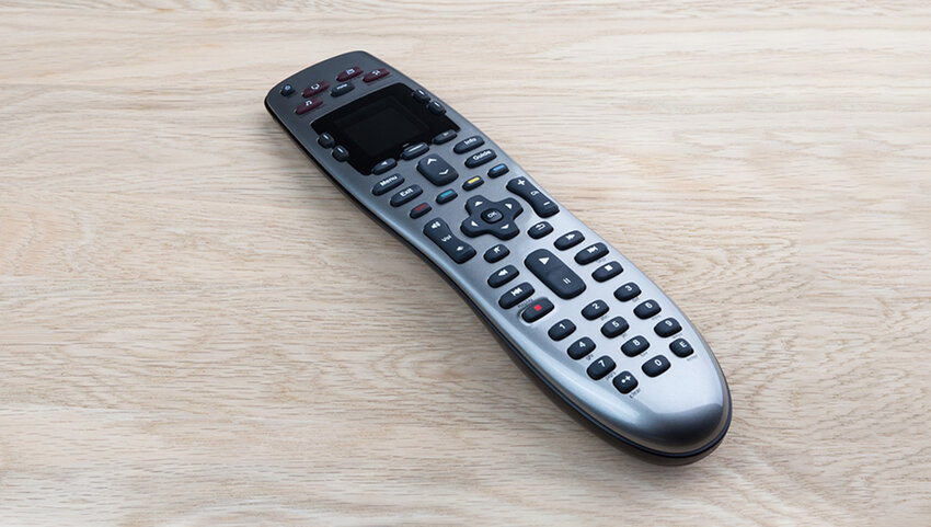 TV remote on wooden table.
