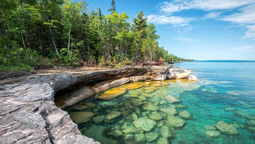 Clear water of Lake Superior and forested land.