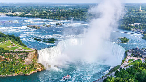 Aerial of Niagara Falls with boat at base. 