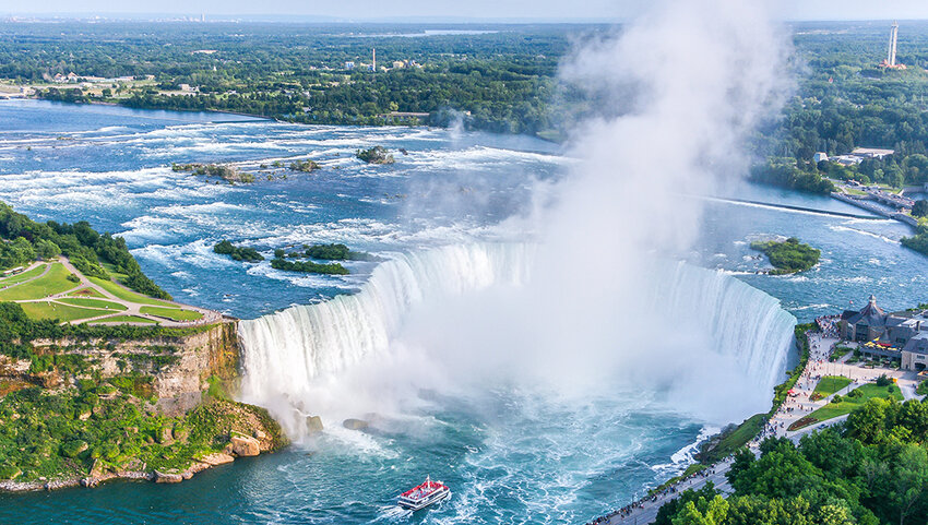 Aerial of Niagara Falls with boat at base. 