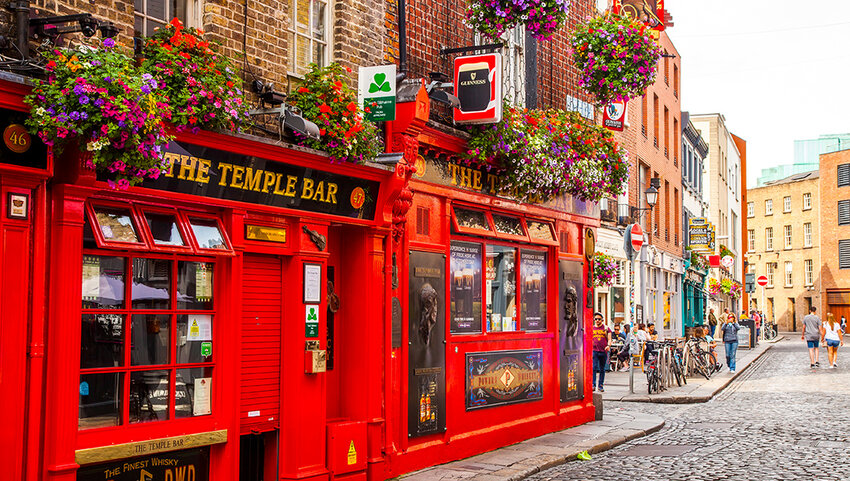 Exterior of red painted bar and cobblestone street. 