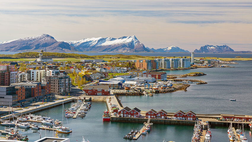 Aerial of Bodo with harbor and snow covered mountains.