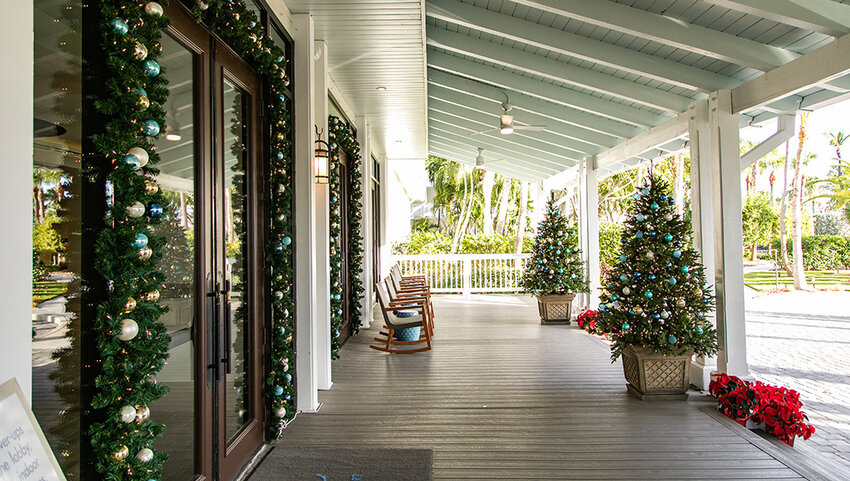 Porch of Hawks Cay Resort with Christmas decorations and decorated trees.