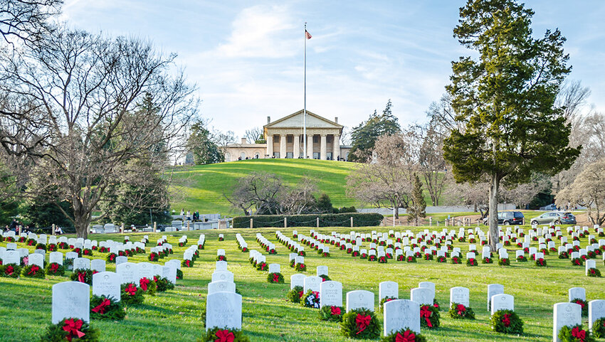Gravestones with wreaths with Arlington House on hill in distance.