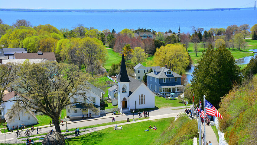 Aerial of houses on Mackinac Island with people walking and on bicycles. 