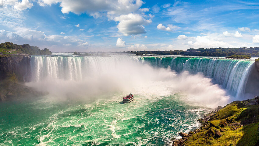 Aerial of Niagara Falls with boat in water. 