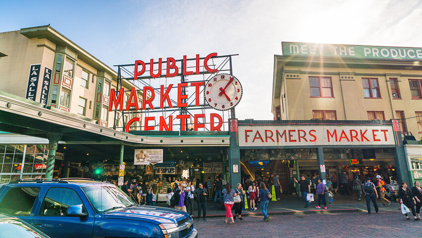 Exterior of Pike Place Market, with many people walking in and out. 