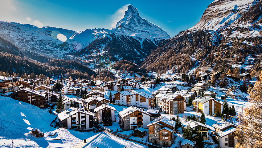 Aerial of the snow covered city of Zermatt with the Matterhorn in distance. 